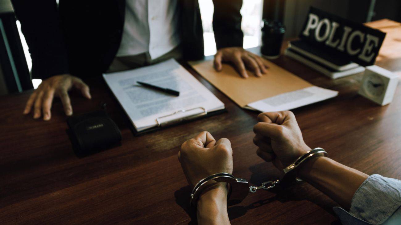 Police officers stand to make allegations about cyberbullying offenses at office room.